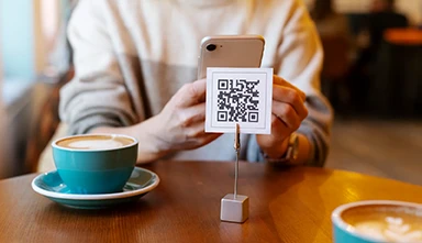 Código QR Argentina - persona escaneando codigo qr en cafeteria